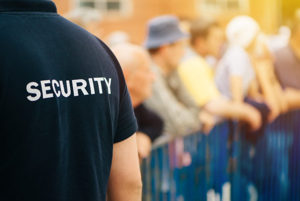 Security guard watching people along a parade route